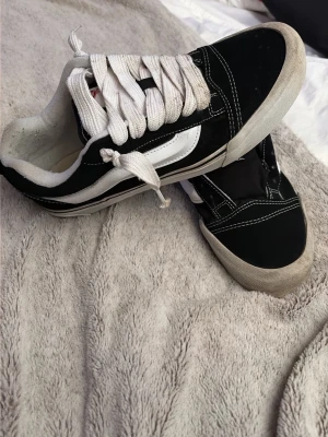 Svarta och vita Vans Old Skool sneakers - Klassiska Vans Old Skool sneakers i svart och vitt med vit sula och vit sidostripes. Skorna har låga skaft, vita snören och kontrastsömmar. Ovandelen är i mocka och canvas vilket ger en snygg och tidlös look. Ett skosnöre är trasigt, men skickas med ändå. Däremot lätt att köpa nya snören. OBS låda till skorna saknas.