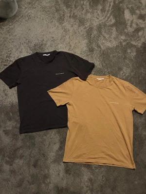 Två Tiger of Sweden T-shirts Pro  - Säljer två stilrena t-shirts pro i svart och beige med diskret text på bröstet. Båda har rund halsringning och korta ärmar. Intill oanvända och mycket enkelt att matcha med andra plagg. Går såklart att köpa seperat o pris går att diskutera!