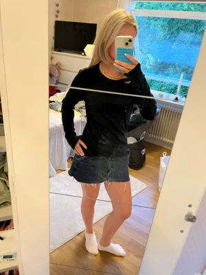 Svart långärmad basic topp - En enkel svart långärmad topp i mjukt och tunt material. Modellen är rak med rund halsringning och långa ärmar, perfekt att styla till jeans eller kjol. Passar dig som gillar minimalistisk och clean stil.