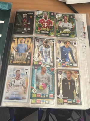 Samling fotbollskort i plastficka - Säljer en samling fotbollskort med olika spelare från Champions League och landslag, snyggt organiserade i en plastficka. Korten har färgstarka designer och visar spelare i matchställ med olika stats och specialeffekter. Perfekt för dig som gillar att samla på fotbollskort. Finns flera, men alla kan inte få plats i bilden