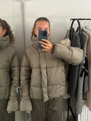 Beige pufferjacka med hög krage - Säljer en beige pufferjacka med boxig passform och hög krage. Passar även S