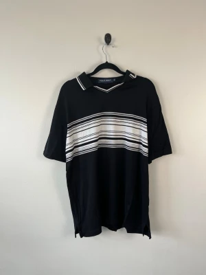 Vintage Polo Golf Ralph Lauren Piké M Svart Vit Randig Pima Cotton Peru Golf Y2K Herr - • Storlek: M • Färg: Svart med vitt mönster  • Passform: Relaxed Fit  • Krage: Pikékrage med V-ringad öppning • Material: 100 % Pima Cotton  Skick: Plagget är i väldigt fint skick med en mindre fläck på bröstet som syns på bild. Eventuella anmärkningar anges alltid tydligt i beskrivningen och visas på bilderna.  Nypris: Cirka 1 300 kr.  📦 Skickas snabbt och packas omsorgsfullt. 💬 Hör gärna av dig om du har frågor eller vill se fler bilder. 🤝 Samfrakt erbjuds vid köp av flera plagg – kika gärna i