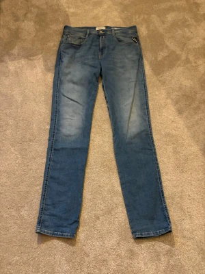 Blå raka jeans med tvättade detaljer - Snygga blå jeans med raka ben och diskreta tvättade partier framtill. Klassisk femficksmodell med knapp och dragkedja. Jeansen har en enkel och stilren look som passar till det mesta. Materialet är denim i bomull.