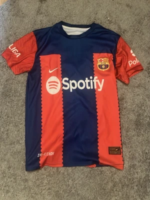 Barcelona matchtröja Pedri nr 8 - Snygg FC Barcelona matchtröja från Nike med Pedri och nummer 8 på ryggen. Tröjan är blå och röd med vita loggor, korta ärmar och sponsorer som Spotify och UNHCR. Perfekt för dig som älskar fotboll och vill stötta Barca på match eller träning.