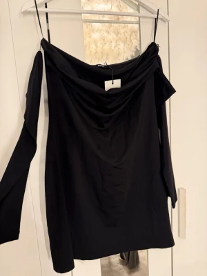 Svart klänning BikBok - Trendig svart klänning från BikBok i storlek L. Klänningen har långa ärmar och en snygg draperad urringning. Perfekt för dig som vill ha en stilren och modern look. Tillverkad i mjukt material som sitter bekvämt.