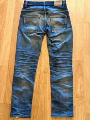Nudie jeans Thin finn - Säljer ett par blå jeans från Nudie Jeans med slitning på vänster lår. Midja 39-40 cm, längd 99 cm. Skriv vid funderingar om storlek eller pris!
