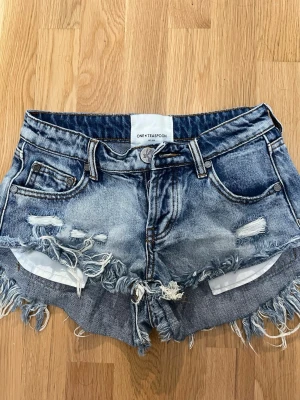 Blå jeansshorts One Teaspoon - Säljer ett par blå jeansshorts från One Teaspoon med råa, fransiga kanter. Köpta för 950