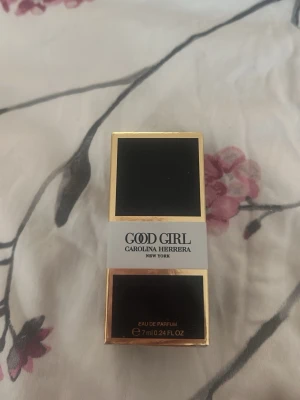 Good Girl parfym 7 ml - Good Girl Eau de Parfum från Carolina Herrera i en elegant svart och guld rektangulär miniflaska på 7 ml. Lyxig design med tydlig logga framtill. Perfekt storlek för att ta med i väskan.
