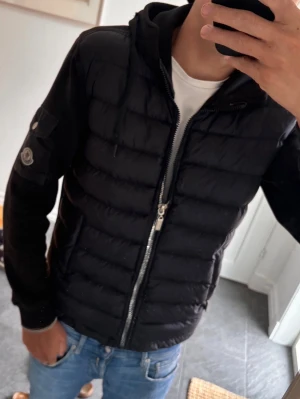  Moncler cardigan - En fet mobiler cardigan som är i bra skick använd fåtal gånger köpt av en polare för 3300 men nu säljer jag för jag ej använder den den är en 1.1a den står L men passar S/m dragkedjan höger har lossnat men kan sättas på igen 