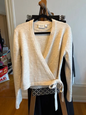 Beige omlottkofta - En beige, stickad omlottkofta från Kappahl med knytband i midjan. Storlek S. Använd 1 gång, mycket bra skick! Kontakta vid frågor💕
