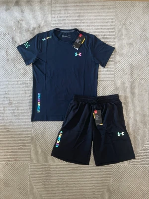 Under Armour Reflective set, T-shirt & Shorts - Strl.M - Hej!  Jag säljer en väldigt snygg Under Armour Reflective set, som är i storlek M.  Allt är i nyskick utan några slitage eller några andra defekter på materialet.  Tröjan och shortsen är väldigt mjuka och bekväma , vilket passar för träning eller sköna vardagar ute i solen.  Kommer från en djur- och rökfritt hem. Fraktas alltid samma dag innan klockan 20, hör av er om ni undrar något!