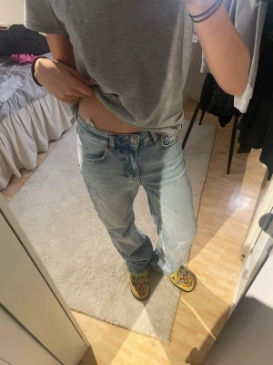 Ljusblå high wide jeans W25 L32 - Säljer ett par ljusblå jeans med hög midja och breda ben. Modellen är high wide och jeansen har klassisk femficksdesign samt gylf med knapp. Perfekta för en avslappnad och trendig look.