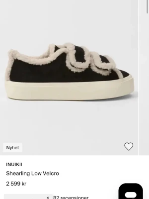 Söker dom här skorna inte för dyra storlek 37/37.5 - Unika svarta sneakers från INUIKII med fluffig beige shearling-detalj och breda kardborreband. Skon har en chunky vit sula och är tillverkad i mocka och fårskinn för en riktigt cozy vibe. Perfekt för dig som vill sticka ut med både stil och komfort.