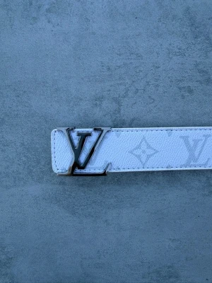 Louis Vuitton-bälte - Louis Vuitton-bälte i vitt med silverfärgat LV-spänne. Stilrentbälte som passar både till vardag och finare outfits 