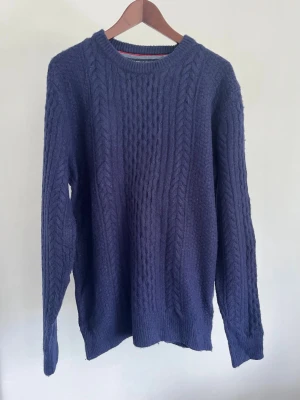Tommy Hilfiger Cable Knit Sweater - Tommy Hilfiger Cable Knit Sweater  Storlek: M Passform: Regular fit Krage: Rund hals (crew neck) Material: 60% lammull 40% nylon Skick: Tröjan är i ett väldigt fint skick utan defekter  Nypris cirka: 1 500 kr