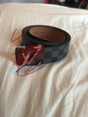 Svart rutigt bälte i skinn - Snyggt svart bälte med rutigt mönster och silverfärgat spänne. Bältet är gjort i skinn och har en klassisk design som passar till många olika outfits. Perfekt accessoar för att lyfta din stil. 2 av hålen är lite skadade men går absolut fortfarande att använda. Om du tänker att bältet är för stort så har jag gjort extra hål så att det kan passa alla. ///PRIS KAN DISKUTERAS