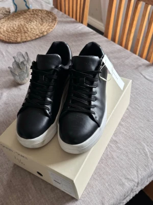 Svarta sneakers från Selected - Säljer en par svarta sneakers från selected i storlek 46 och innermått 29,5 dom är använda engång så nästan helt nya lite smutsiga under inget mer. Ny pris 1199 mitt pris 900 har kvittot dom är köpte för ca en månad sedan