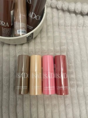 Isadora bronzer och glow sticks - Fyra smidiga stick-produkter från Isadora: contour stick i kall brun, glow stick i ljus beige, glow stick i rosa och blush stick i mörkare rosa. Perfekta för att skulptera, highlighta och ge färg till ansiktet. Praktiska stift i plastförpackning.