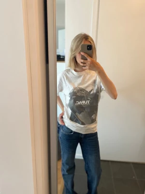 Vit t-shirt med Tupac tryck - Säljer en vit t-shirt i storlek M med stort svartvitt Tupac-tryck på framsidan. T-shirten har klassisk passform och korta ärmar. 50 kr!