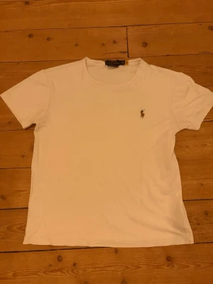 Ralph Lauren T-shirt - Klassisk vit t-shirt från Polo Ralph Lauren med liten broderad logga på bröstet. Modellen är custom slim fit.