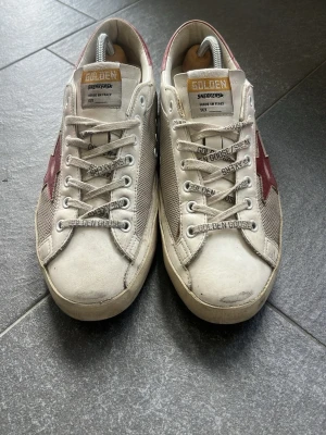 Golden Goose Superstars med röd stjärna - Golden Goose Superstars med röd stjärna. Riktigt snygga golden goose skor i bra skick. Perfekt till vardags. Skick 7/10. Skorna är köpta nya från miinto för ca 5000 kr. 