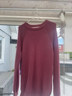 Mörkröd stickad tröja - En enkel och stilren mörkröd stickad tröja från Zara med rund halsringning och långa ärmar. Tröjan har ribbade muddar vid hals, ärmslut och nederkant. Storlek S