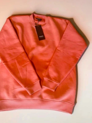 Ljusrosa sweatshirt i bomull - En stilren ljusrosa sweatshirt med rund hals och långa ärmar. Tillverkad i mjuk bomull och har ribbade muddar vid ärmslut och nederkant. Perfekt för dig som gillar en enkel och clean look.