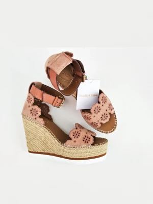 See by Chloé rosa kilklackade sandaler  - Snygga kilklackade sandaler i ljusrosa mocka från See by Chloé. Sandalerna har broderade blommor, öppen tå och justerbart ankelband med guldfärgat spänne. Klacken är flätad i jute och sulan har en vit gummidetalj för extra stil.