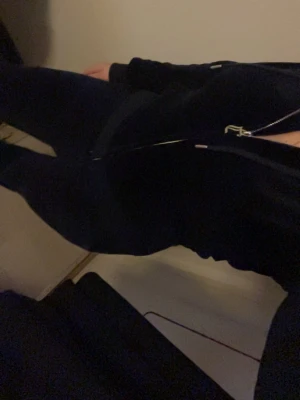 Marinblått velourset från Juicy Couture - Marinblått sett från Juicy Couture i storlek XXS. Setet består av en ziphoodie med dragkedja och matchande byxor med resår i midjan. Perfekt för chill dagar hemma eller när du vill vara extra bekväm.
