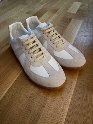 Maison margiela skor - Snygga sneakers i vitt och beige med ovandel i mocka och textil. Skorna är i nytt skick, ny pris 6500kr, utan box.