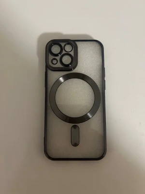 Transparent mobilskal med MagSafe-ring för iphone 13 mini - Snyggt transparent mobilskal med svart ram och inbyggd MagSafe-ring. Skalets baksida är frostad och har förstärkta kanter runt kameran för extra skydd. Passar perfekt för dig som vill ha ett stilrent och modernt skydd till din mobil.