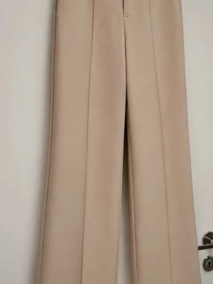 Beige vida kostymbyxor - Eleganta beige kostymbyxor med hög midja och vida, raka ben. Stilren modell med pressveck framtill som ger en klassisk och sofistikerad look. Perfekta till kontoret, middagar eller en chic vardagsoutfit. En tidlös bas i garderoben som är enkel att styla med bäde stickat, skjorta och klackar. I mycket fint skick. Storlek: S Skick: Mycket fint skick #kostymbyxor #beigebyxor #tailoredtrousers #wideleg #widelegpants #highwaist #dresspants #oldmoney #quietluxury #minimalist #beige #elegant #capsule