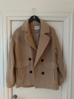 Beige kort kappa NA-KD - Säljer denna korta kappa från Nakd. Använd fåtalet gånger💕