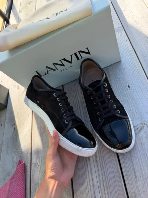 Svarta Lanvin sneakers med lackdetaljer - Lanvin dbb1 patent cap toe i svart | storlek 8 eu42 men passar 43 | väldigt bra skick | box och dustbags medföljer vid köp, online kvitto finns | pris går att diskutera vid snabb och enkel affär | sulkräm har använts | 