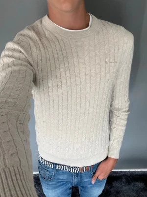 Kabelstickad tröja  - Säljer denna snygga kabelstickade tröja från bondelid i en beige färg i riktigt bra skick!