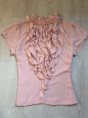 Ljusrosa blus med volangdetaljer - super söt blus med volanger, jättefin och passar till allt skriv privat för mer bilder !