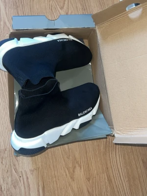 Speed Trainer svarta sneakers - Svarta Speed Trainer sneakers med vit chunky sula och stickad strumpdesign. Skorna har B-logga på sidan och är tillverkade i stretchigt textilmaterial för en tight och bekväm passform.