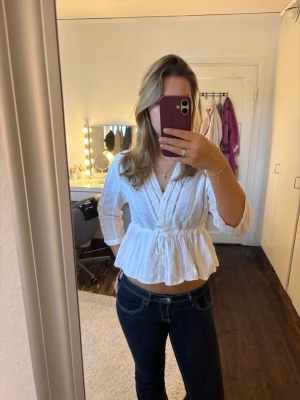 Vit blus NAKD - Söt vit omlottblus med spetsdetaljer och brodyr från NAKD. Blusen har v-ringning, volang nedtill och trekvartsärm💕