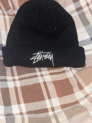 Stüzzy mössa - Säljer denna mössan då jag inte passar i möss och den bara har legat och släpat hemma hos mig. Den är i jättebra skick då den nästan aldrig är använd och bara legat på en hylla, och då jag inte använder den så är det lika bra att sälja den. Kontakta mig om ni vill ha mer bilder, info etcetera. Pris kan diskuteras.