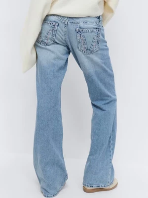 Real low loose jeans  - Säljer ett par ljusblå bootcut jeans med slitningar på båda knäna och klassiska fem fickor. Jeansen har låg midja och en avslappnad passform. Snygga detaljer på bakfickorna och tillverkade i denim med en skön känsla.
