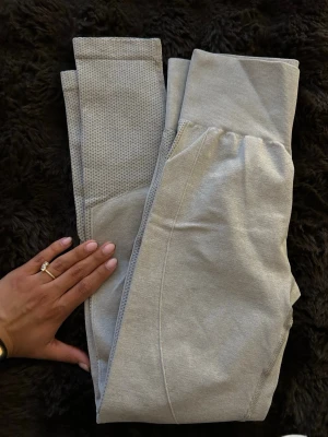 Ljusgrå seamless leggings✨ - Säljer ett par ljusgrå seamless leggings med hög midja och ribbad linning. Materialet är stretchigt och bekvämt, med meshdetaljer på nedre delen av benen för extra ventilation. Perfekta för träning eller chill dagar. Skriv privat vid intresse 