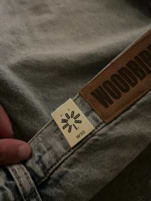 Grå denimshorts från Woodbird helt nya - Säljer ett par grå denimshorts från Woodbird med klassisk femficksdesign och hög midja. Shortsen har en avslappnad passform och är tillverkade i slitstark bomull. Perfekta för dig som gillar en enkel men snygg stil.