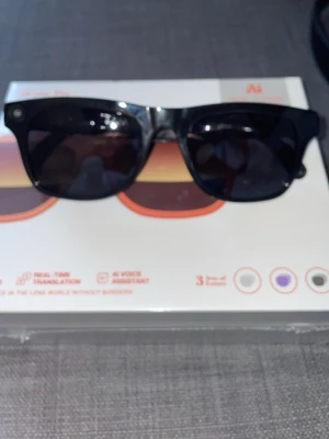 Meta glasögon kopia - Smarta glasögon xk one Pro i orange plast med inbyggd HD-video, realtidsöversättning och AI-röstassistent. Glasögonen levereras med tre olika linser och har en modern, sportig design. Perfekt för dig som vill ha teknik direkt i glasögonen.