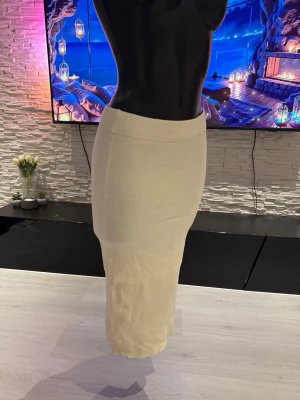 Ljusbeige ribbad långkjol - Säljer en stilren ljusbeige långkjol i ribbat material. Kjolen har en kroppsnära passform och är perfekt för dig som gillar en enkel men trendig look. Passar till både sneakers och boots för en avslappnad vibe.