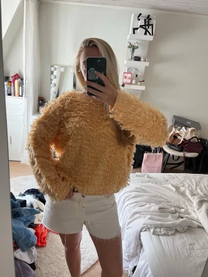 Gul fluffig stickad tröja - Säljer en supermysig gul stickad tröja med fluffig, loopy textur. Tröjan har en relaxed passform och långa ärmar, perfekt för dig som vill ha något både trendigt och bekvämt. Passar till både jeans och kjol för en cool vardagslook.