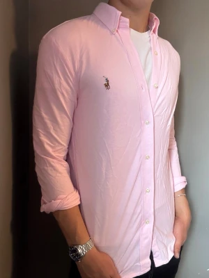 Ralph Lauren skjorta rosa – S Featherweight - Säljer denna stilrena och snygga rosa Ralph Lauren skjorta i storlek S. Skjortan är i Featherweight och har ett skönt pikéliknande material. Mycket bra skick förutom missfärgningar de sista bilderna. . Har du några frågor? Tveka inte att höra av dig. Allt gott från Deluxe Garderoben ⭐️