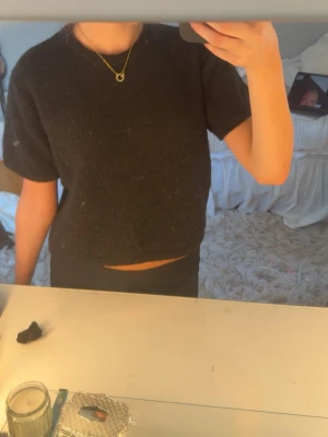 svart croppad stickad topp - svart croppad stickad topp med korta ärmar, inga defekter och använt ett fåtal gånger!!