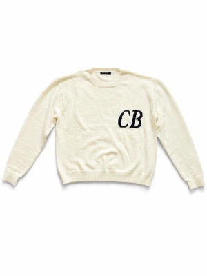 Vit stickad tröja Cole Buxton - Vit stickad tröja från Cole Buxton med svarta bokstäver 'CB' broderat på bröstet. Tröjan har rund halsringning, ribbade muddar och är tillverkad i mjukt stickat material. Enkel och stilren design som passar till mycket.