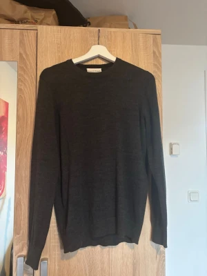Mörkgrå stickad tröja Bruun & Stengade - Snygg mörkgrå stickad tröja från Bruun & Stengade. Tröjan har rund halsringning, långa ärmar och är tillverkad i ett mjukt, tunt material.          Den passar ej längre, har använt den max 2 gånger