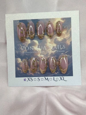 Mirage (XS);Medium Almond - Snygga handgjorda press-on naglar i nude med cateye tippar, och unika leopard mönster som är guldfärgade längs kanterna. Formen är medium lång almond och de kommer i storlek XS: 14 mm, 11 mm, 11,5 mm, 10 mm, 8 mm. Perfekt för dig som vill ha en trendig och kreativ nagelstil.